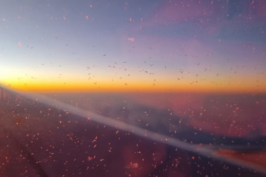Sunset View from Airplane Window with Glowing Horizon and Ice Crystals photo