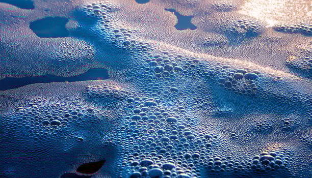 Bubbles Floating on a Serene Water Surface at Sunrise, Creating a Tranquil Atmosphere photo