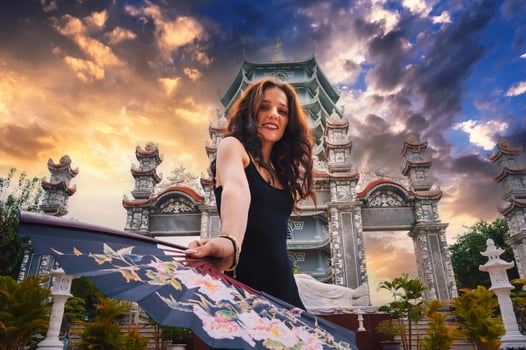 Portrait of a happy young woman tourist traveler with a fan at temple on Buddhist pagoda in Da Nang, Vietnam. Travel and tourism in Asia photo