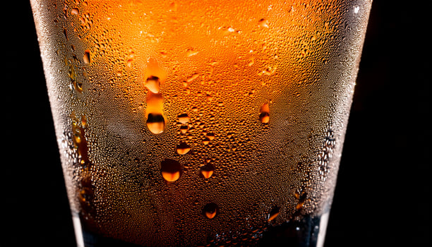 Refreshing Beverage With Condensation in a Clear Glass Illuminated by Soft Light Showcasing Vibrant Colors photo