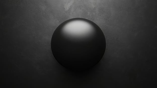 Dark sphere shaped form with a bright highlight on a textured surface photo
