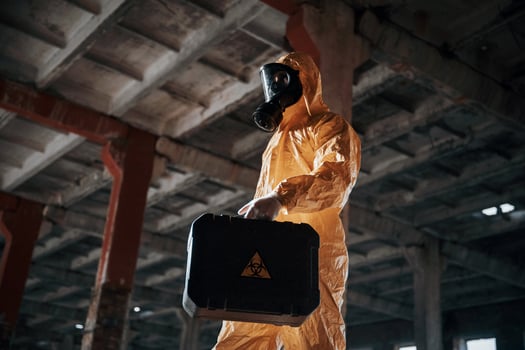 Bottom view.. Man dressed in chemical ,,protection suit in the ruins of the post apocalyptic building photo