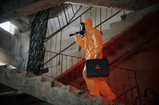 On the stairs. .Man dressed i,n chemical protection suit in the ruins of the post apocalyptic building photo