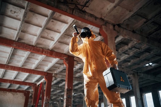 Bottom view. Man dressed in chemical protection suit, in the ruins of the post apocalyptic building photo