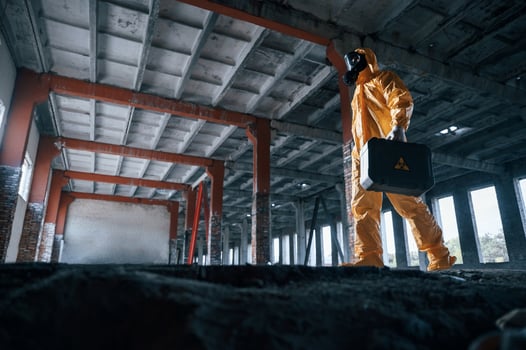 View from, below. Man dressed in chemical protection suit in the ruins of the post apocalyptic building photo