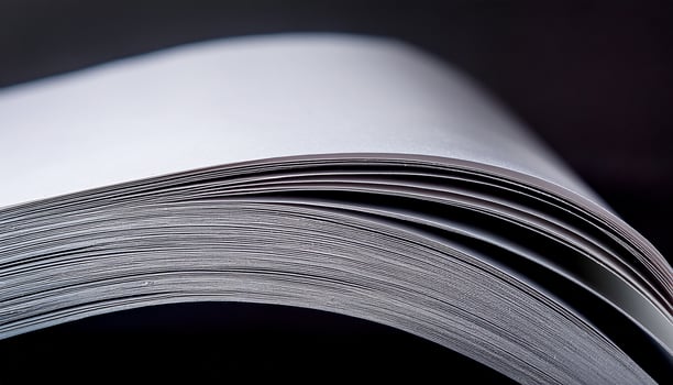 Close-up View of Open Blank Book Pages Showing Fine Details of Paper Texture in Low Light Setting photo