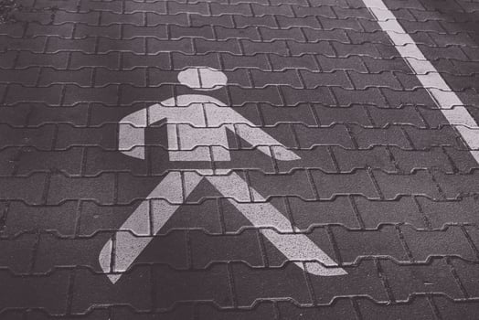 Walking symbol on pavement indicates pedestrian crossing zone in an urban area photo
