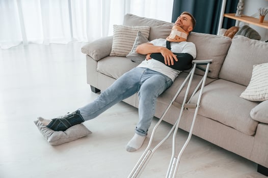 Pain in the arm. Man with crutches is at home indoors. Having injuries photo