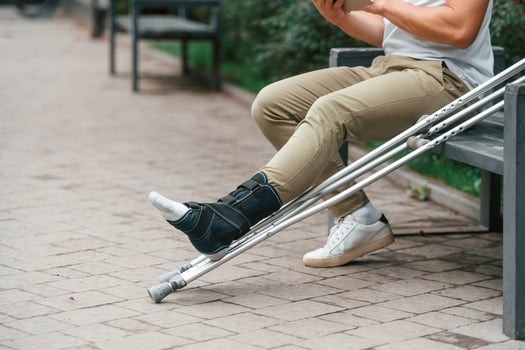 Close up view of the legs.. Man with crutches is in the park outdoors photo