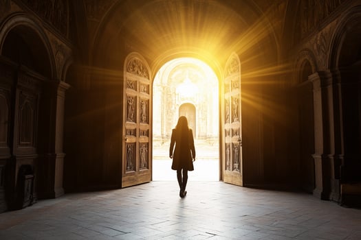 A woman is walking into an open door at the end of a hallway photo