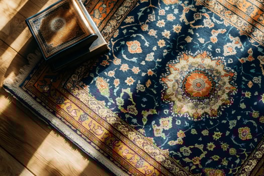 Sunlight shining on ornate prayer rug and holy books on wooden floor photo
