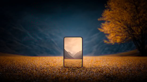 A smartphone displaying a serene mountain landscape in an autumn field at sunset photo