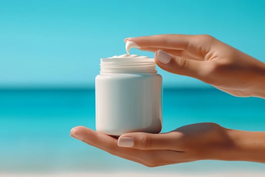 Woman holding moisturizing cream at the beach on sunny summer day photo