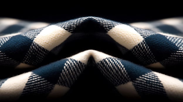 Close-up view of a folded checkered fabric showcasing intricate patterns against a dark background photo