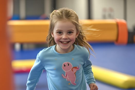 Happy girl running and smiling in playful indoor playground photo