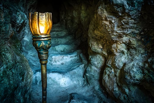 Illuminated Stone Pathway Mystical Cave Entrance with Glowing Torch photo
