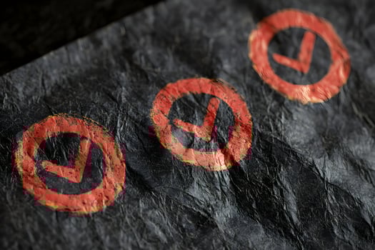 Red Checkmarks on Crumpled Dark Paper Background Texture photo