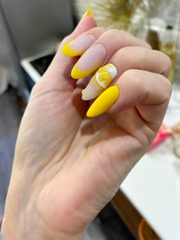 A hand with a beautiful yellow lemon manicure. photo