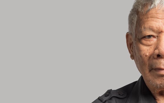 Close-up of senior man half face standing on a gray background photo