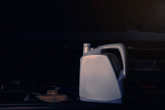 Changing engine oil or fuel from an engine lubricant bottle Service industry, automobiles and engine repair technolog. photo