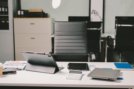 An office desk with a laptop, tablet and other items photo