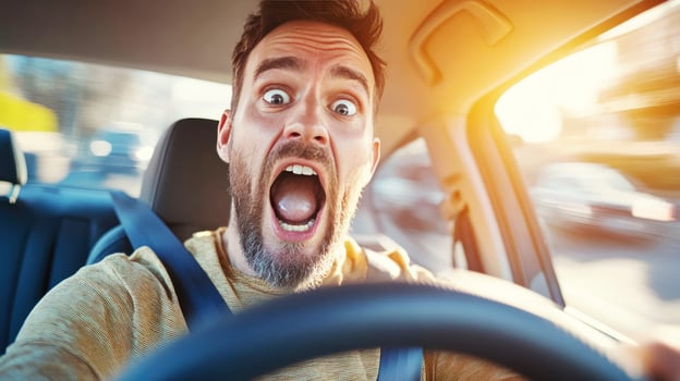 Man driving a car with an expression of shock and excitement in a busy city street photo