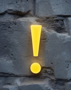 Glowing exclamation mark on stone wall background photo