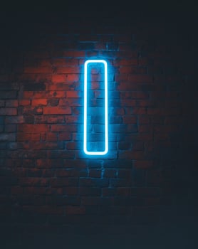 Blue neon light illuminating a brick wall at night photo