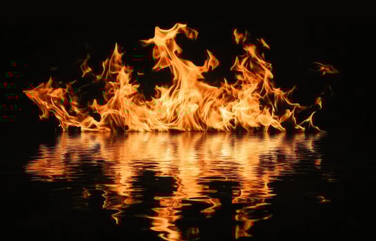 Flames reflected in dark water on black background photo