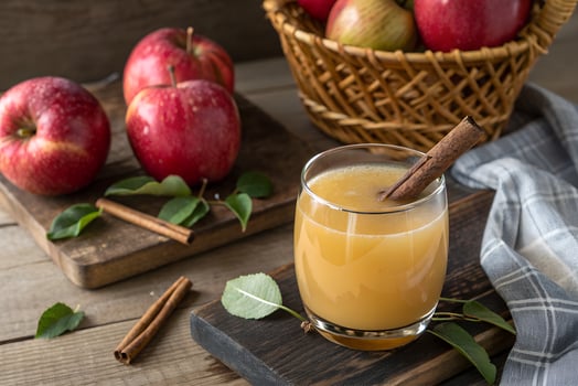 Fresh Apple Juice with Cinnamon and Apples on Wooden Table photo