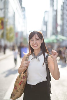 Asian woman walking in the street with a bag photo