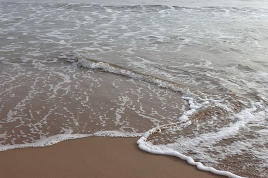 Beautiful waves on the sand beach in the morning photo