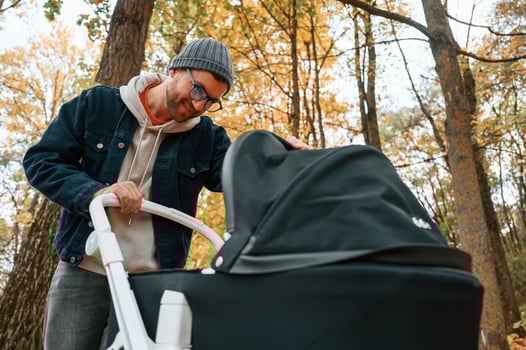 Looking ,inside the pram. Man is having a walk in the autumn park photo