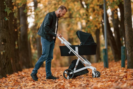 Man with ,pram is having a walk in the autumn park photo