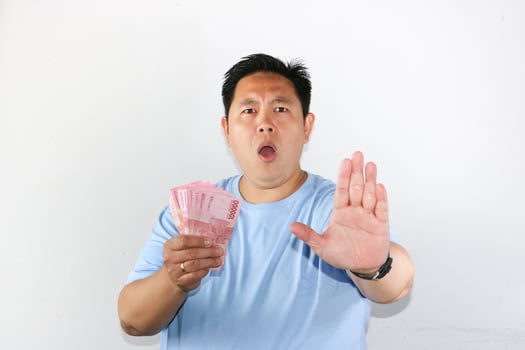 A man holding a pink dollar bill with his hands up photo