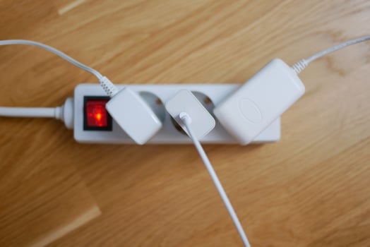 Three electric cables are plugged into a power strip extension cord photo