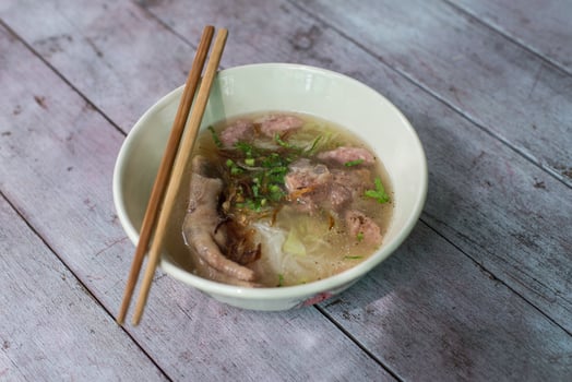Noodles in a bowl placed on a wooden table photo
