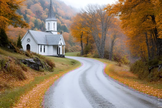 Winding road leading to a white church in autumn landscape photo