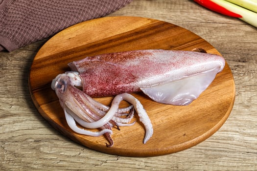 A squid on a wooden cutting board photo