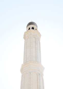 A serene white mosque minaret against a bright sky photo
