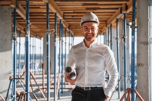 Standing ,and, smiling. Man is working on the construction site at daytime photo