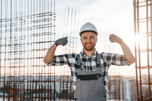 Showing biceps. Conception of succes. Man is working on the construction site at daytime photo