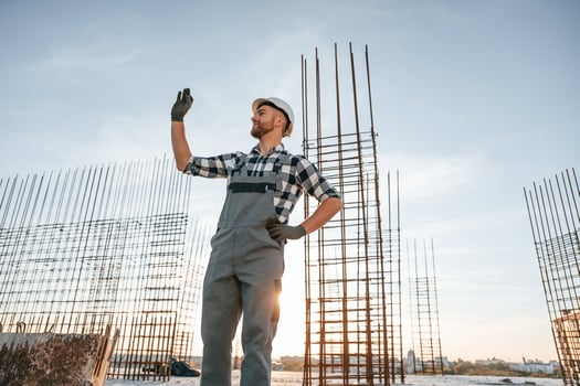 With, hand up. Giving the orders.. Man is working on the construction site at daytime photo