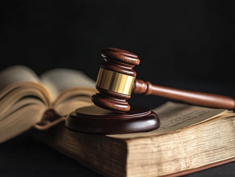 Gavel and Aged Book on Dark Surface photo