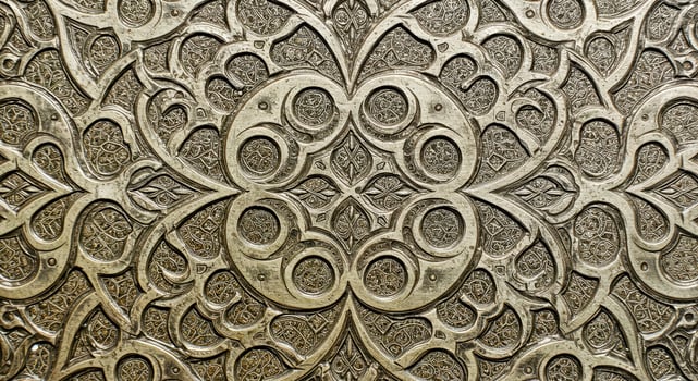 An ornate metal wall with a pattern photo