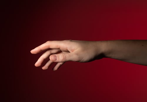 Hand reaching out, fingers gently stretching, pointing, showing subtle, graceful motion. Woman with photo