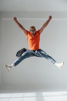 Happy guy is jumping, screaming and celebrating success. Handsome man is in the studio against white background photo