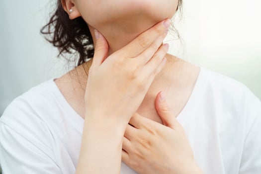 Asian woman touching her neck and throat for thyroid gland problem. photo