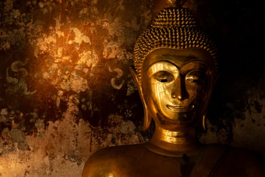 Gold buddha statue in front of the old wall background at Thai temple. photo