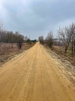 Empty Dirt Road Through Rural Landscape, Cloudy Sky, Natural Scenery, Travel, Remote Location. High quality photo